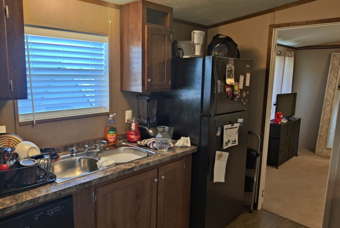 Fridge and kitchen of single wide manufactured home for sale in River's Edge, Clinton Township | Manufactured home buying in MI