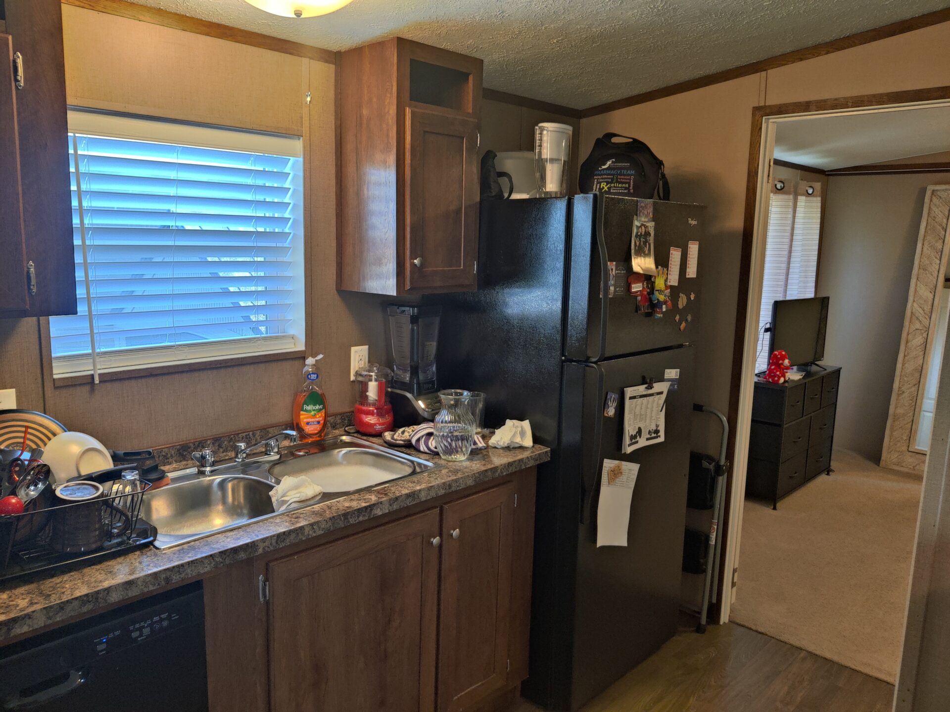 Fridge and kitchen of single wide manufactured home for sale in River's Edge, Clinton Township | Manufactured home buying in MI